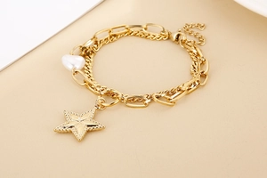 Detail of golden double-layer chain bracelet featuring star charms and heart pearls