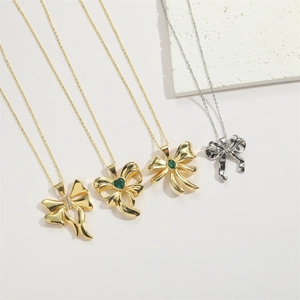 Close-up of gold and silver bow pendants with heart-shaped colorful zircons