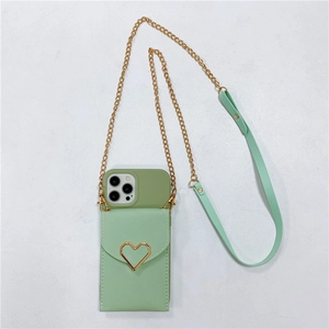 Detail of mint green crossbody phone bag featuring a gold heart buckle and chain strap
