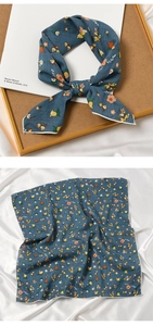 Detailed view of blue floral square scarf with fine white rolled edges and elegant pattern