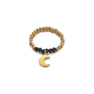 Detailed macro view of elastic daisy ring with black faceted beads and gold moon charm