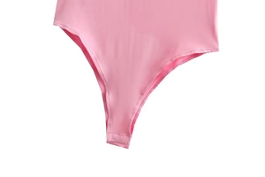 Dettaglio del fondo del body rosa con tessuto elastico e chiusura con bottoni a pressione
