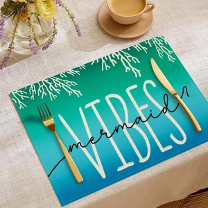 Detail of teal gradient linen placemat with coral pattern and Mermaid Vibes text