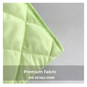 Detail of light green quilted nylon fabric showing fine stitching and soft texture