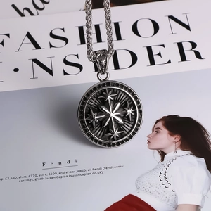 Detailed view of a vintage round compass pendant on a woven wheat chain necklace