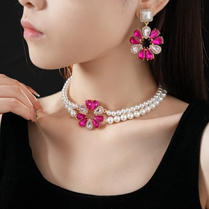 Dettaglio girocollo di perle e set di gioielli con pendente a fiore rosa