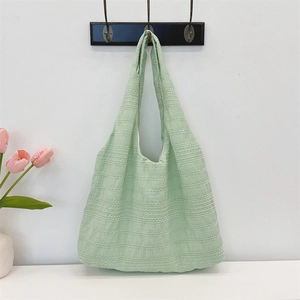 Detail of light green tote bag with seersucker texture and wide shoulder strap