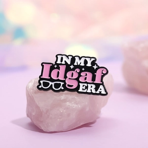 ERA series alloy badge with IN MY Idgaf ERA text displayed on a pink crystal stone
