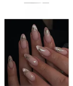 Close-up of almond press-on nails with silver cat eye gradient and gold 3D bow detail