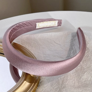 Close-up of elegant mauve satin padded headband on a decorative golden mirror frame
