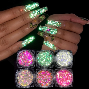 Macro view of six colorful reflective nail glitters showing glow in the dark effect