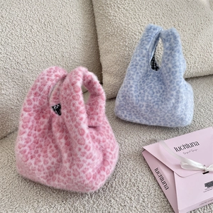 Détail de sacs à main en fausse fourrure léopard rose et bleu avec doublure à carreaux