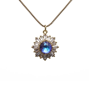 Gold sunflower necklace featuring a blue gemstone center and sparkling zircons