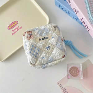Detailed macro view of quilted cotton sanitary pad pouch with bear pattern and blue rope zipper