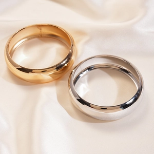 Polished gold and silver metallic round bangles set on elegant white satin fabric