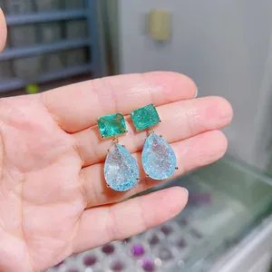 Macro detail of emerald green and cracked ice blue crystal drop earrings with gold plating