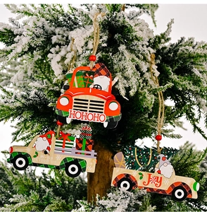 Three wooden Christmas truck ornaments hanging on a snowy branch with festive text
