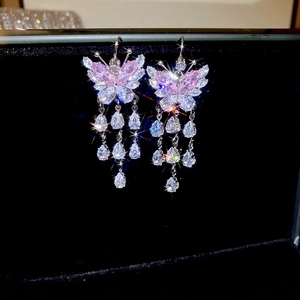 Macro detail of butterfly earrings with pink cubic zirconia and teardrop tassels
