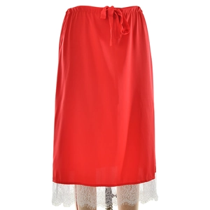 Détail d'une jupe midi en satin rouge avec ourlet en dentelle blanche et taille élastique
