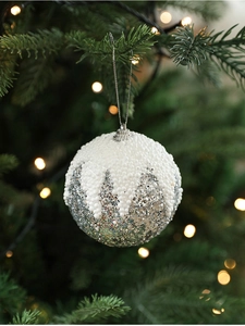 Détail de la boule de Noël en mousse blanche avec paillettes argentées sur sapin