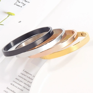 Polished stainless steel bangles in silver, gold, rose gold, and black finishes on white tray
