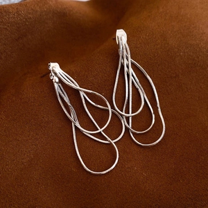 Détail de boucles d'oreilles argentées avec franges multicouches en chaîne serpent
