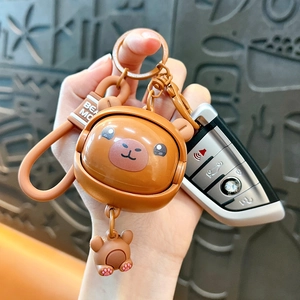 Cute rotatable face capybara keychain with brown strap being held by hand