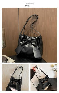 Detail of black tote bag with oversized bow, long ribbons and dual thin straps