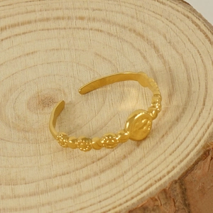 Bague vintage ajustable en or avec relief floral et disque martelé sur bois naturel