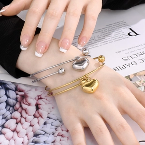 Fashionable minimalist heart charm open bangles in 18K gold and silver finishes