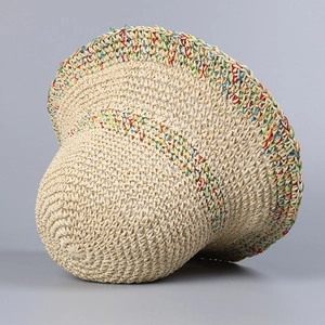 Detail van een handgeweven beige zonnehoed met kleurrijke geweven streeptexturen
