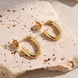 Orecchini a perno ovali lucidi a forma di U in oro su base minimalista in pietra beige