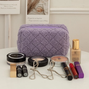 Detail of purple teddy velvet pencil case with quilted texture and makeup storage items