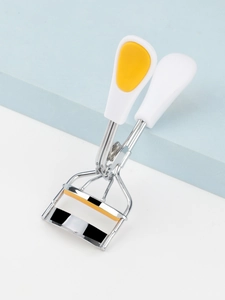 Macro detail of high-shine steel eyelash curler with colorful striped silicone pad