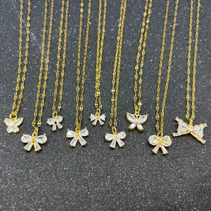 Détail de pendentifs papillon dorés avec zircons sur un fond noir scintillant élégant