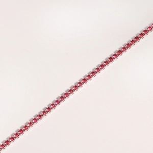 Macro view of silver claw-set tennis bracelet with continuous round pink zircons