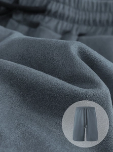 Close-up of blue knit shorts featuring elastic waistband, black drawstring and fabric texture