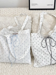 Chic canvas tote bag with heart patterns and bow details on soft textured fabric