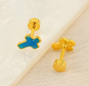 Macro view of gold cross stud earrings with gradient blue enamel and screw back design