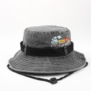 Detail of embroidered train and black drawstring on a washed denim kids sun hat