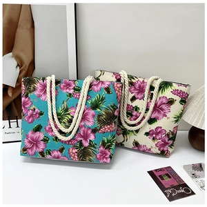 Detail of printed canvas tote bags with tropical hibiscus patterns and thick rope handles