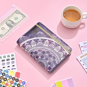 Detail of purple mandala budget binder with cash envelopes, stickers and gold elastic strap