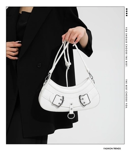 Close-up of white crescent shoulder bag featuring Y2K silver heart buckles and hardware