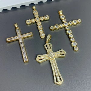 Set of four gold-plated cross pendants with cubic zirconia inlay on grey leather background