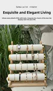 Detail of a four-tier bamboo jewelry display stand with white velvet bars on a white chair