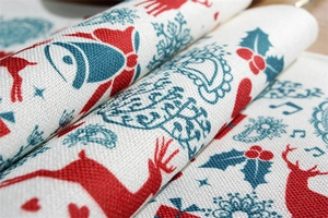 Macro shot of thick polyester-cotton placemat with festive Christmas reindeer and bell patterns
