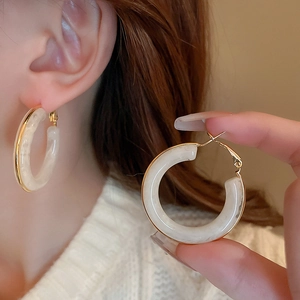 Close-up of vintage resin hoop earrings with marble texture and gold plated metal trim
