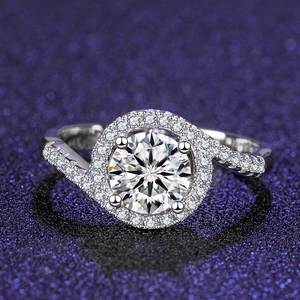 Macro shot of a four-prong halo engagement ring with pavé diamonds on a purple background