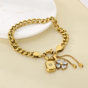 Detail of gold Cuban link bracelet featuring star square and zircon clover pendants