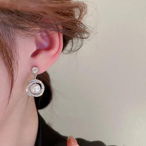 Close-up of elegant silver flower earrings with sparkling cubic zirconia and white pearl